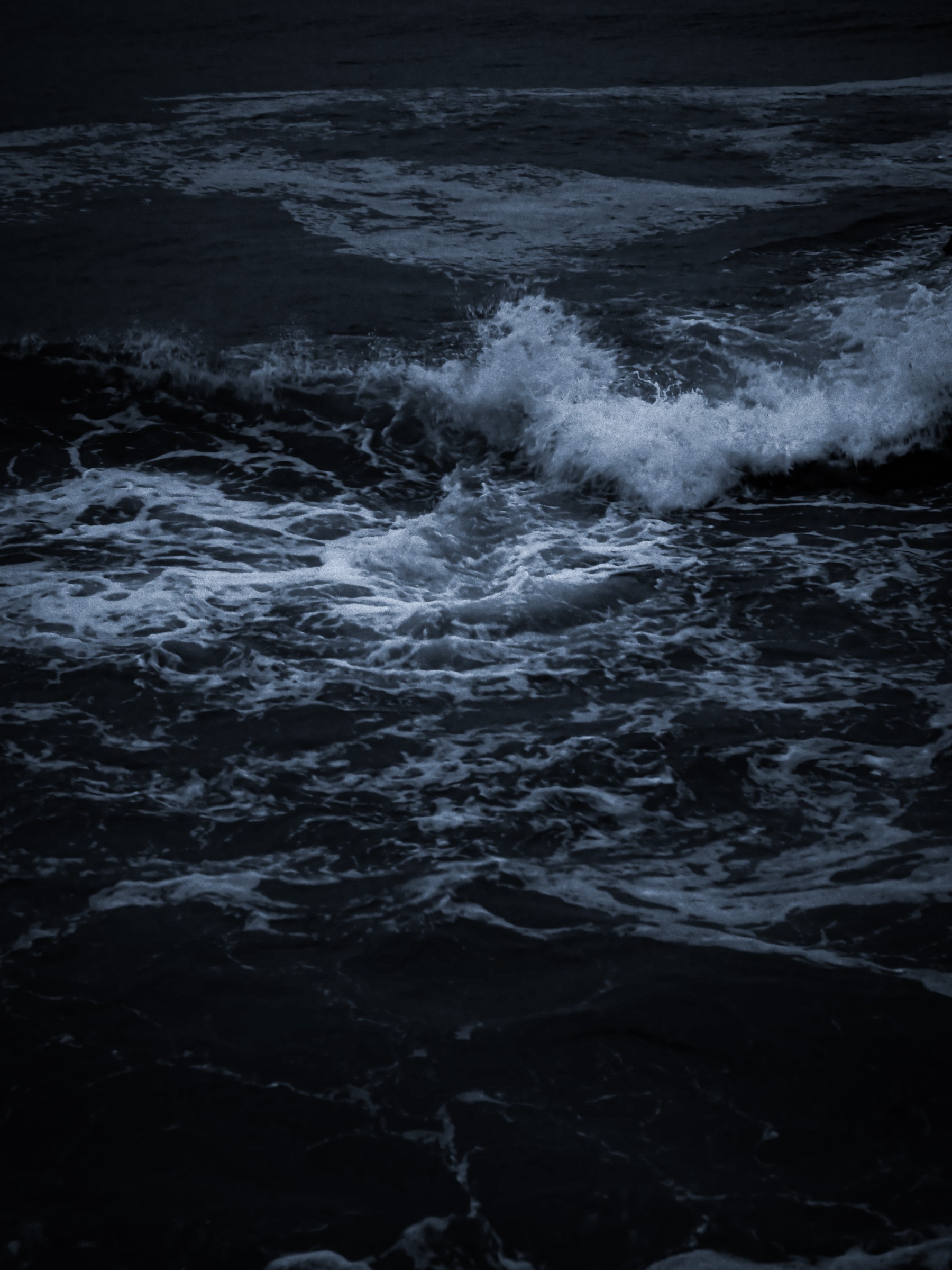 Dark waves breaking at dawn, photo by Byron Lambert