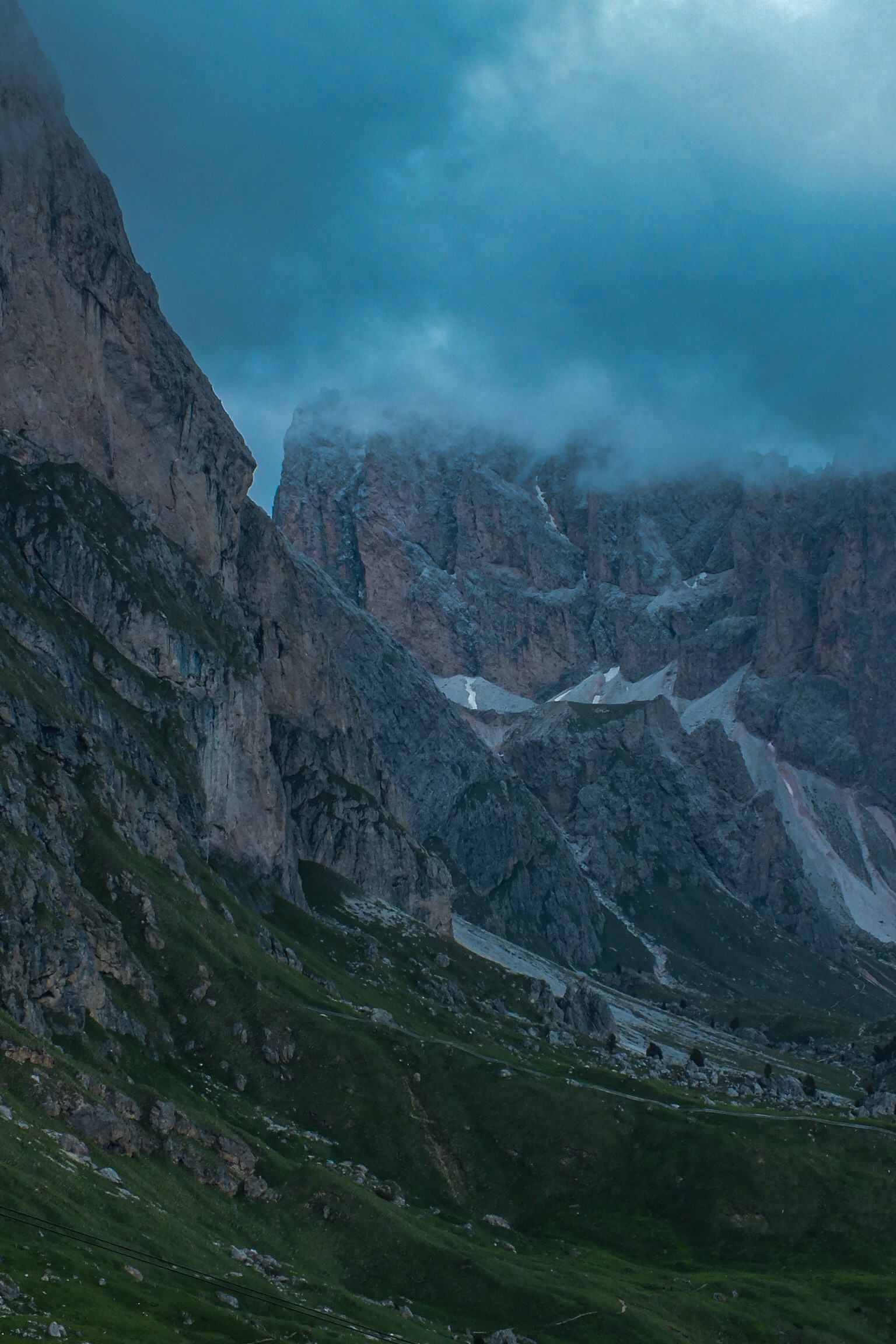 Rocky peaks in cloud above a green mountain valley, photo by Byron Lambert