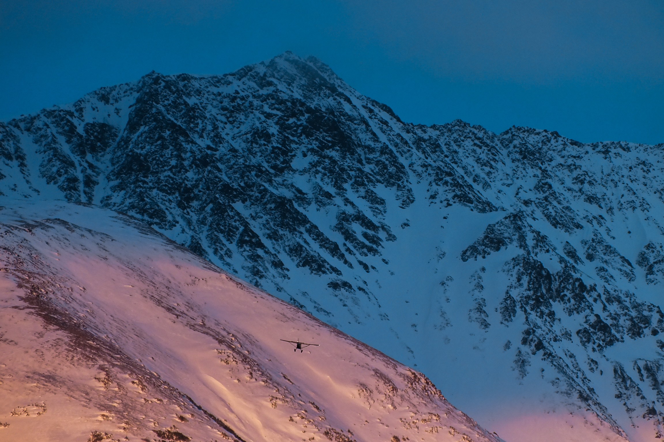 A snow-covered mountain ridge in morning light, photo by Byron Lambert